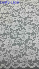 Tecido de renda em branco, decorado com delicados padrões florais e bordas luxuosamente enroladas