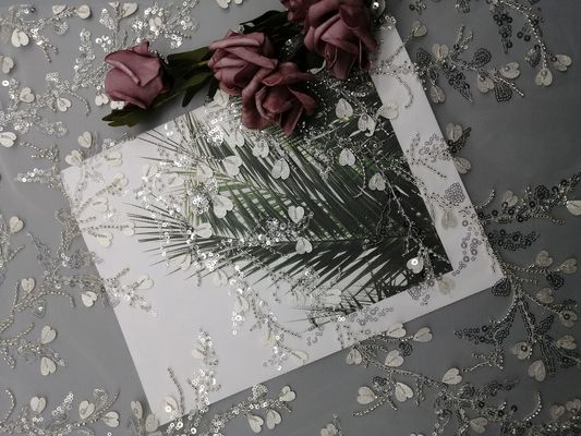 A lantejoula branca do vestuário fêmea ata tela frisada do bordado