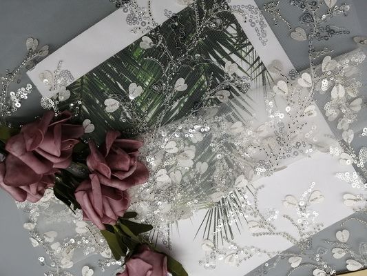 A lantejoula branca do vestuário fêmea ata tela frisada do bordado