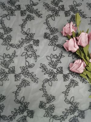 Bordado amarrado da flor preta por todo o lado na malha do tule da prata da tela do laço