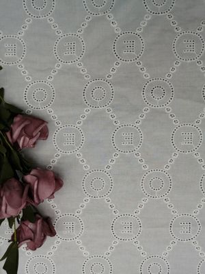 O laço do teste padrão da letra bordou o pano do vestido do bebê da tela do ilhó