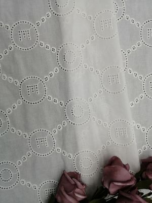 O laço do teste padrão da letra bordou o pano do vestido do bebê da tela do ilhó