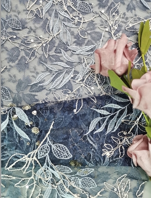 O tule azul bordado ata o laço da flor da tela com lantejoulas